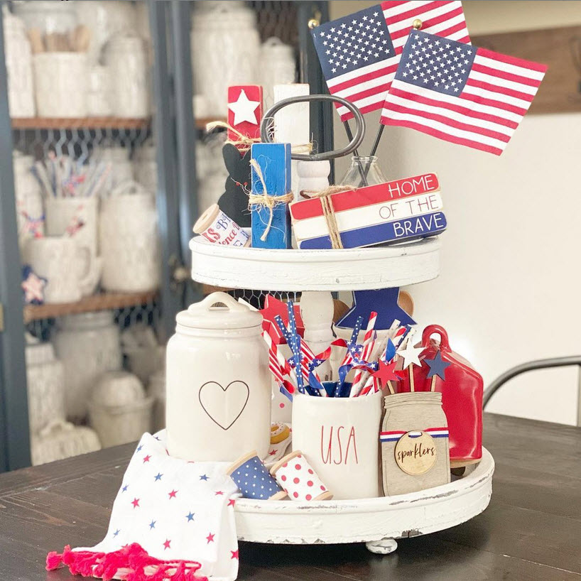 A two-tier white tray with Rae Dunn decor for 4th of July