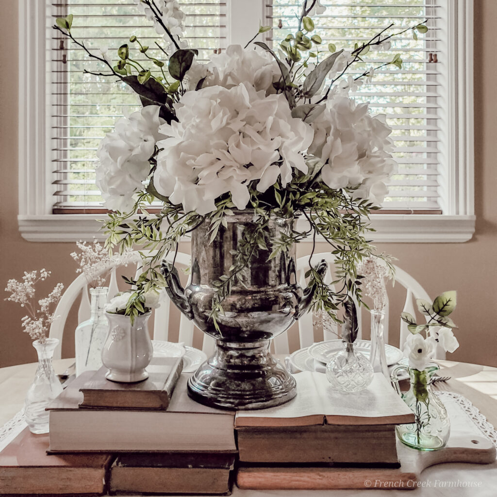 A vintage champagne bucket makes a perfect vase for a romantic floral arrangement on a dining table